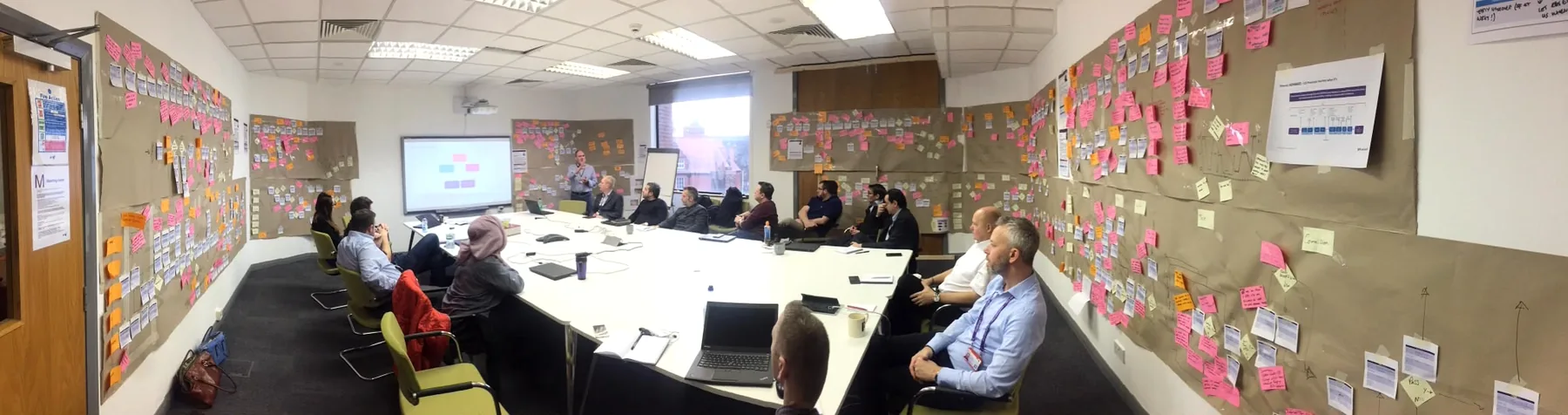 Newgate consultants and client team working around a large wall-based process map